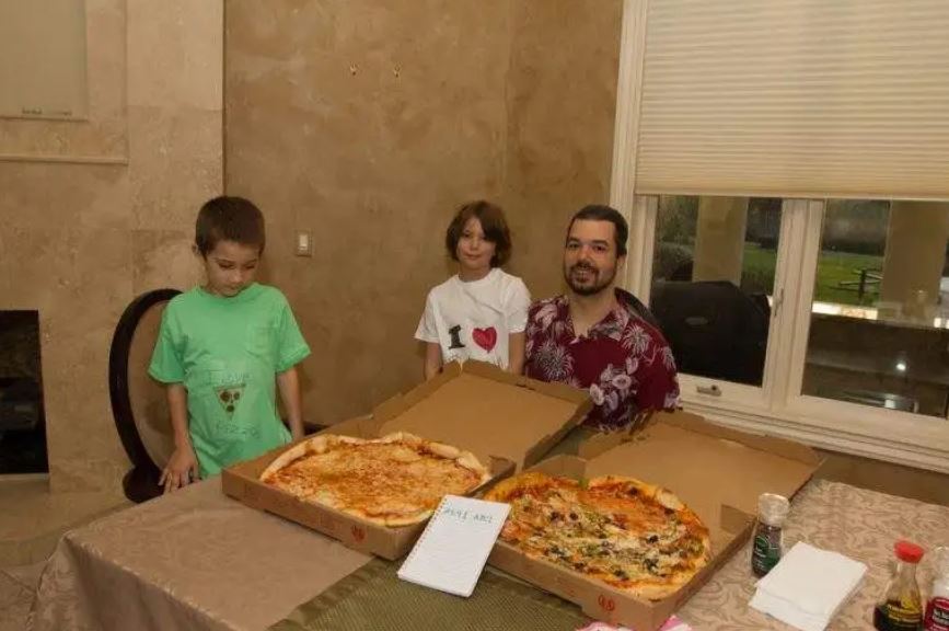 Laszlo com filhos e as duas pizzas compradas com bitcoin sob a mesa