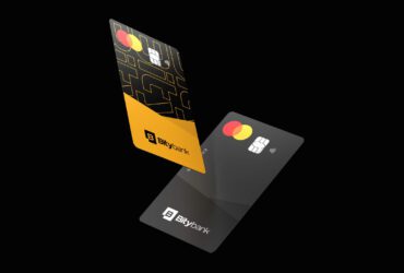 Fundo preto com dois cartões a frente e ao centro. Um cartão é amarelo com preto e outro somente preto. Os dois tem selo mastercard, chip e logo da Bity.